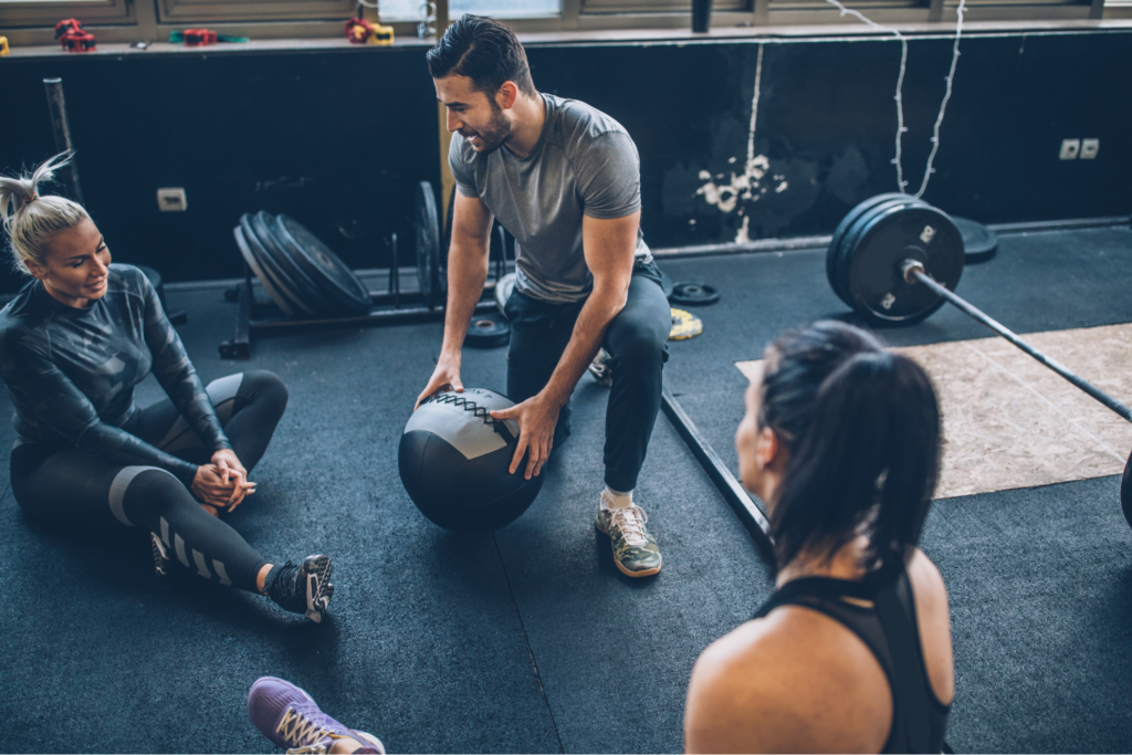 Trainer im Gespräch mit einem Fitnessstudio-Mitglied in einer CrossFit-Box 