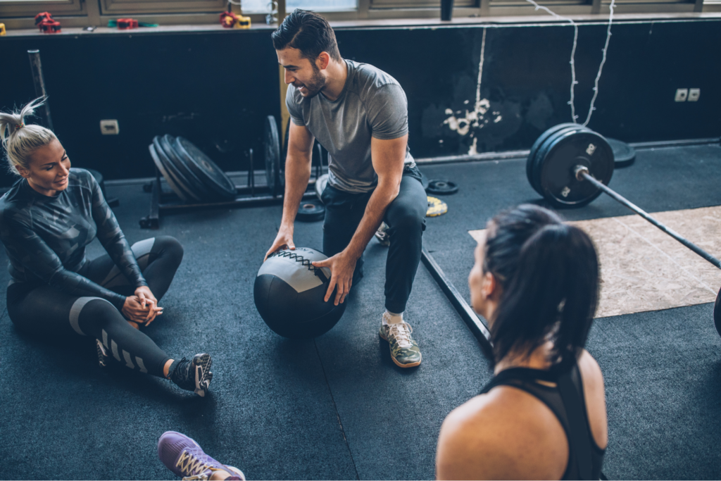 L'entraîneur parle à un membre de la salle de sport dans une salle de CrossFit 